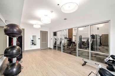 Exercise room with light wood-type flooring