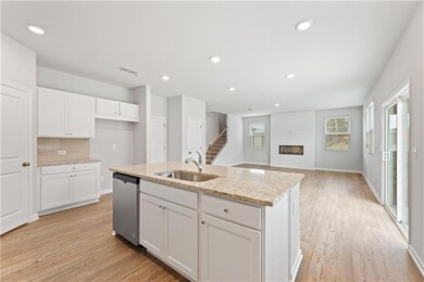 Kitchen featuring white cabinetry, sink, stainless