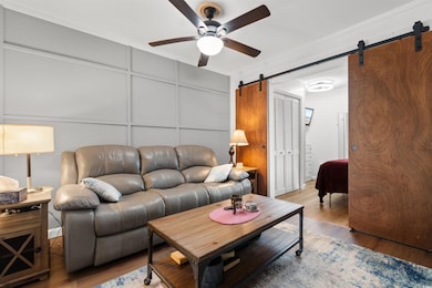 Living room with a barn door, a decorative wall, w