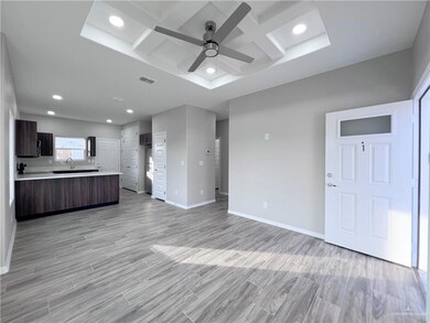 Unfurnished living room featuring coffered ceiling, a ceiling fan, recessed lighting, baseboards, and light wood-type flooring