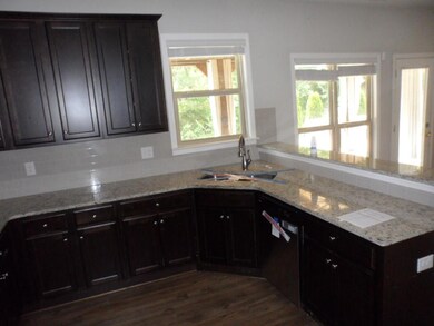 Kitchen featuring a sink, dishwasher, backsplash, a peninsula, and light stone counters