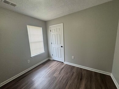 Unfurnished room with dark wood finished floors, a textured ceiling, and baseboards