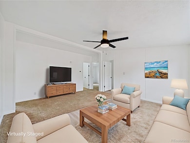 Carpeted living room featuring ceiling fan