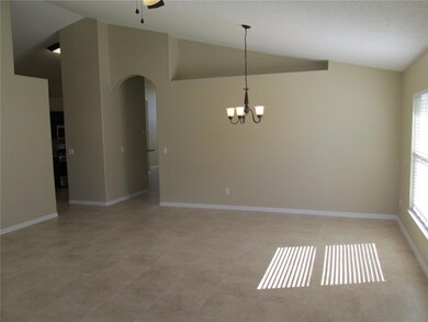View from living area to dining area.  Kitchen to left and family room to the right.  Notice vaulted ceiling and plant ledge.