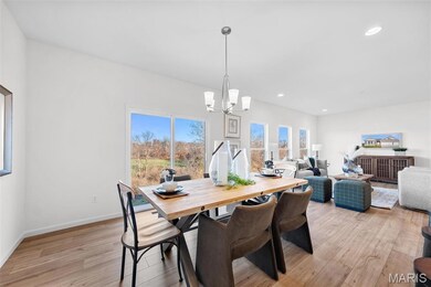 Dining area with light wood finished floors, recessed lighting, and a chandelier