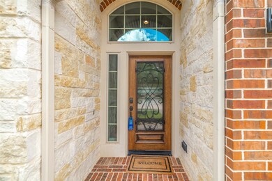 Beautiful stone flanks the wooden reeded glass door with the ornate iron detail adding character.