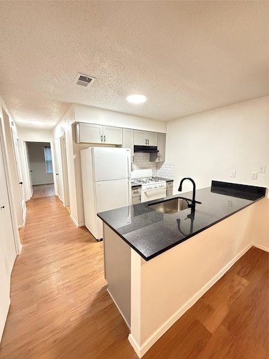 Kitchen featuring freestanding refrigerator, rang