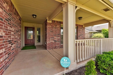 View of exterior entry with brick siding and covered porch