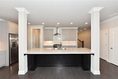 Kitchen featuring ornamental molding, wall chimney