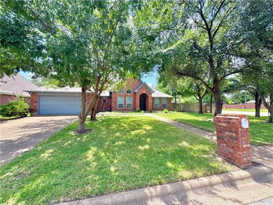 View of front facade with brick siding, driveway,