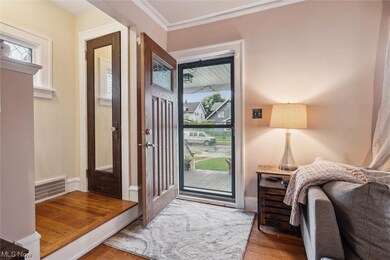 Foyer with a wealth of natural light, crown molding, and dark wood-type flooring
