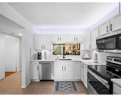 Kitchen with light tile patterned flooring, stainl