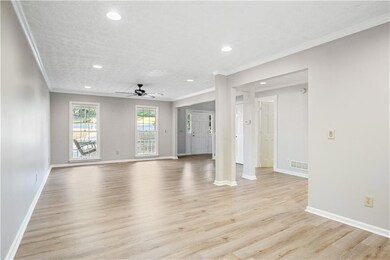 Unfurnished living room featuring ceiling fan, orn