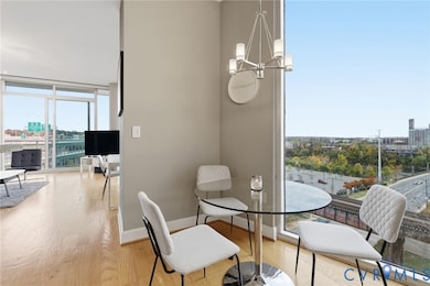 Dining space with expansive windows, light wood-style floors, a chandelier, and a city view
