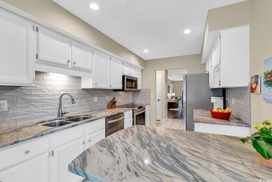 Kitchen with sink, decorative backsplash, white ca