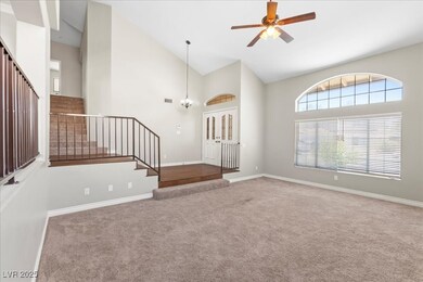 Carpeted foyer entrance with stairway, high vaulte