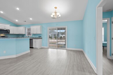 Kitchen featuring lofted ceiling, white cabinetry,