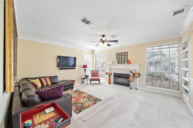 The living room enjoys views of the resort-like backyard and includes built in shelving, gas fireplace and easy access to the kitchen area.