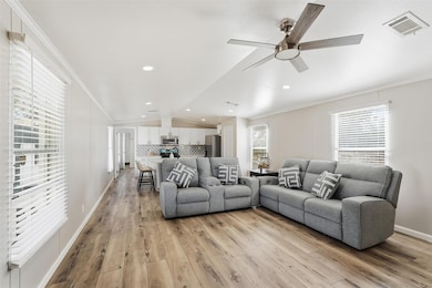 Living room featuring light wood finished floors, recessed lighting, ceiling fan, lofted ceiling, and ornamental molding