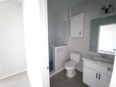 Bathroom with vanity, toilet, baseboards, and a stall shower