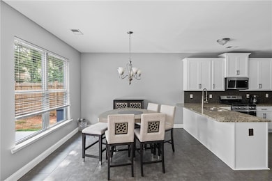 Dining room featuring plenty of natural light, a chandelier, and dark tile patterned flooring