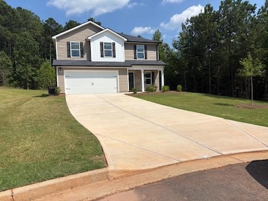 View of front of house with a garage, driveway, and a front lawn