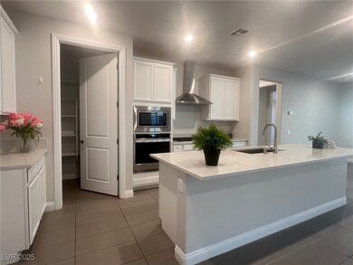 Kitchen featuring wall chimney range hood, stainle