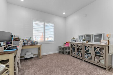 Office with light colored carpet and recessed lighting off the entryway with double doors.