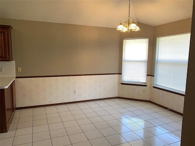 Unfurnished dining area with lofted ceiling, a chandelier, wallpapered walls, and baseboards