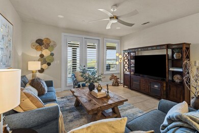Living room featuring baseboards, a ceiling fan, visible vents, and light tile patterned floors