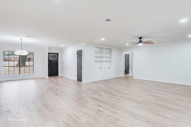 Unfurnished living room featuring crown molding, b