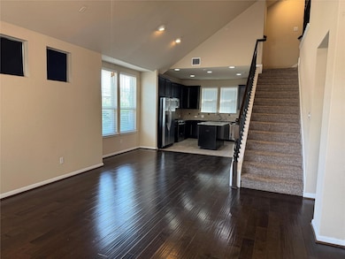 Unfurnished living room with healthy amount of natural light, stairway, lofted ceiling, dark wood-style flooring, and recessed lighting