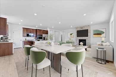 Dining area with a fireplace, light wood-style floors, and recessed lighting