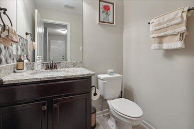 Bathroom with toilet, vanity, and tile patterned f