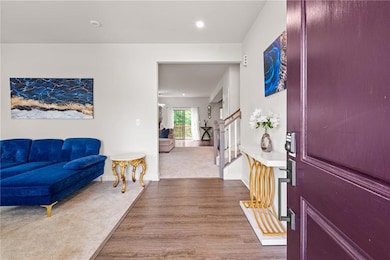 Entryway with wood finished floors, stairway, baseboards, and recessed lighting