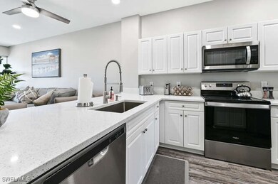 Kitchen with stainless steel appliances, open floor plan, white cabinetry, and recessed lighting
