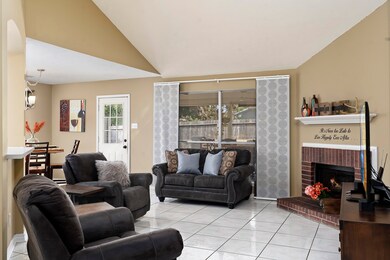 Living Room with tile flooring and gas log fireplace. Bar seating available at counter tops.