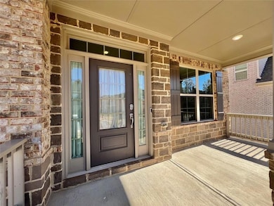 View of exterior entry featuring a porch, stone siding, and brick siding