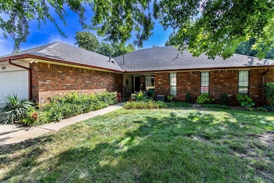 Ranch-style house featuring a garage, a front lawn, brick siding, and a shingled roof