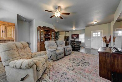 Living room featuring a ceiling fan, wood finished floors, and baseboards