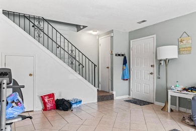 Foyer with stairs, tile patterned floors, a textur