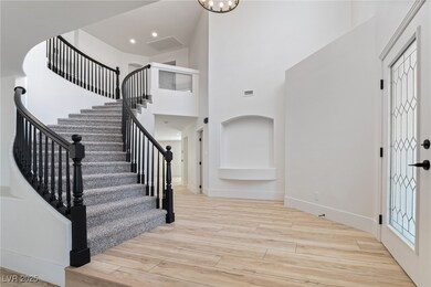 Foyer entrance with stairs, a high ceiling, wood f