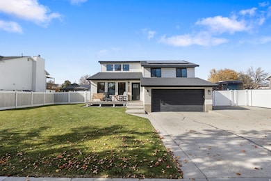 View of front of property featuring a gate, concrete driveway, solar panels, a garage, and a shingled roof