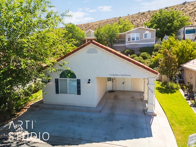 Back of house with stucco siding, a mountain view, and a lawn