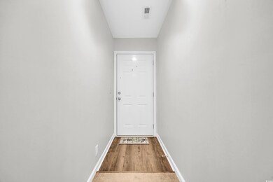 Doorway with wood finished floors, visible vents, 