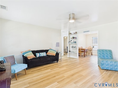 Living room featuring wood finished floors and a ceiling fan