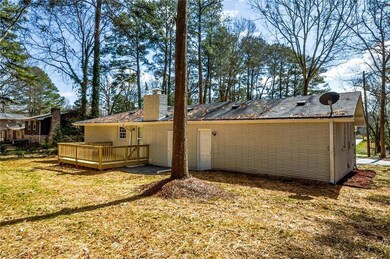 Rear view of property with a deck and a lawn