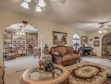 Living room featuring visible vents, arched walkwa