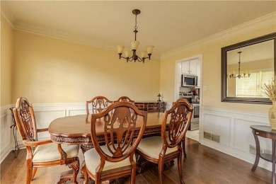 Dining space featuring a chandelier, crown molding