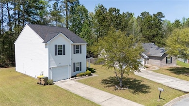 Traditional-style house with driveway, an attached garage, and a front lawn